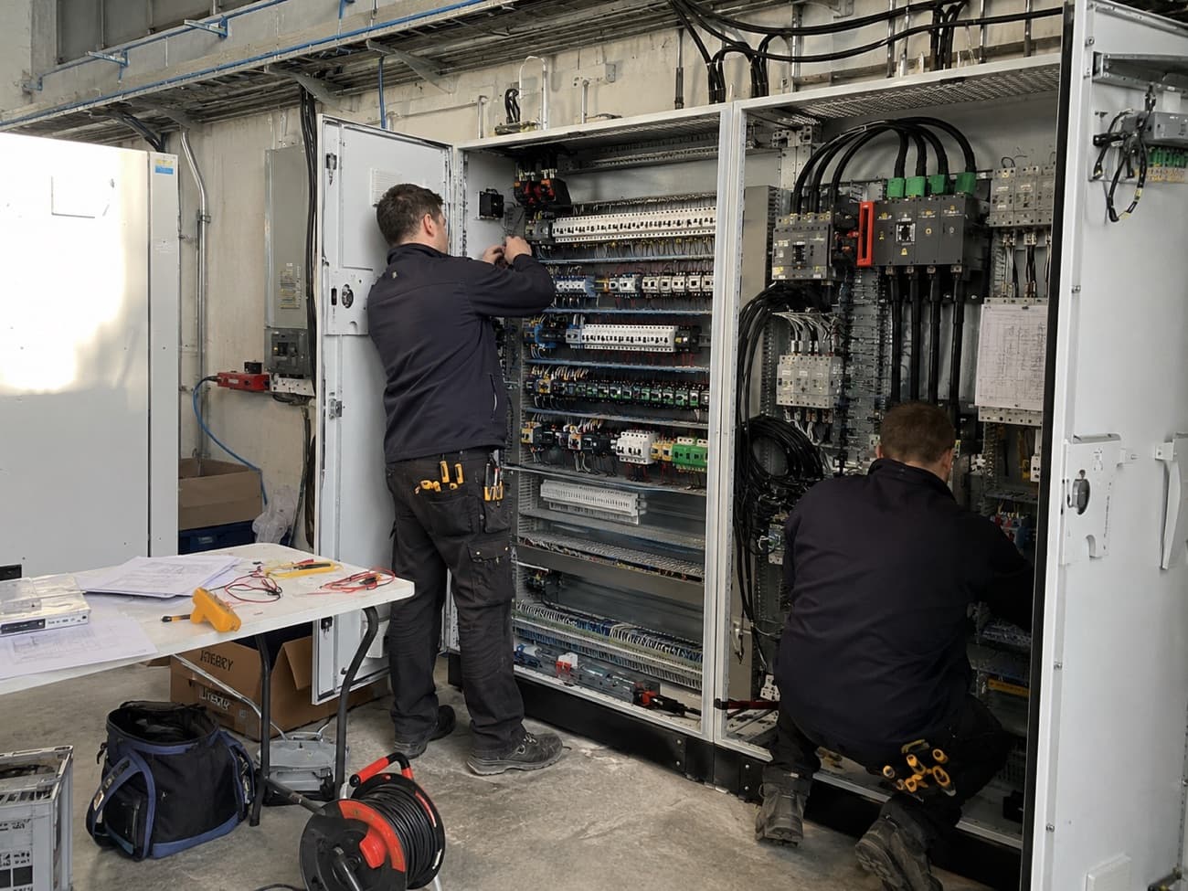 Électriciens au travail sur des armoires électriques